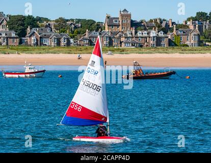 North Berwick, East Lothian, Écosse, 8 août 2020. Météo au Royaume-Uni : journée idéale pour les sports nautiques. Une chaude journée ensoleillée dans le Firth of Forth attire les gens à prendre à l'eau. East Lothian Yacht Club organise une course de club tandis qu'un garçon naviguant sur un topper naviguant à bord d'un canot sort de West Bay Banque D'Images