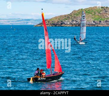 North Berwick, East Lothian, Écosse, 8 août 2020. Météo au Royaume-Uni : journée idéale pour les sports nautiques. Une chaude journée ensoleillée dans le Firth of Forth attire les gens à prendre à l'eau. East Lothian Yacht Club organise une course de club. Un petit canot à voile avec des enfants à bord et un skiff de Musto naviguent vers l'île Craiglieth Banque D'Images