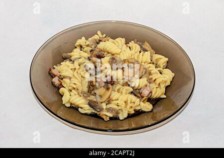 Assiette transparente avec pâtes spaghetti carbonara à la crème, champignons, bacon. Banque D'Images