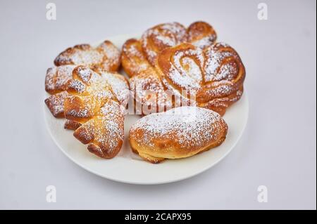 un petit pain sucré sur une assiette à fond blanc Banque D'Images