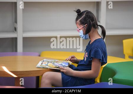 Haikou, province chinoise de Hainan. 8 août 2020. Un enfant lit à la bibliothèque provinciale de Hainan pendant les vacances d'été à Haikou, dans la province de Hainan, dans le sud de la Chine, le 8 août 2020. Credit: Pu Xiaoxu/Xinhua/Alay Live News Banque D'Images