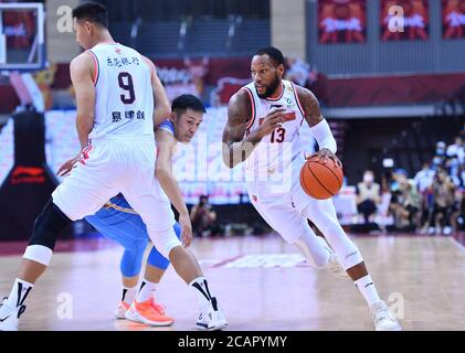 (200808) -- QINGDAO, le 8 août 2020 (Xinhua) -- Sonny Weems (R) de Guangdong Southern Tigers traverse le match semi-inal entre Guangdong Southern Tigers et Beijing Ducks à la ligue 2019-2020 de l'Association chinoise de basket-ball (CBA) à Qingdao, dans la province de Shandong en Chine orientale, le 8 août 2020. (Xinhua/Zhu Zheng) Banque D'Images