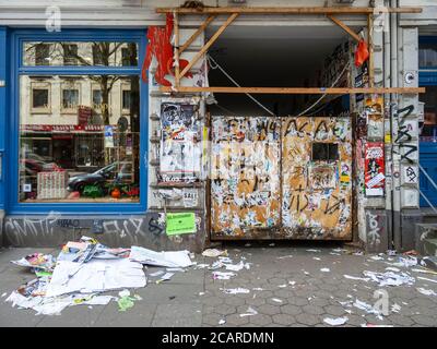 Vestiges d'affiches et de graffiti sur les portes d'une porte à Schanzenstraße. Les restes d'affiche sont dispersés sur le trottoir, Hambourg, Allemagne. Banque D'Images