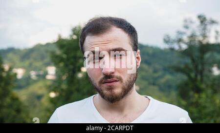 Homme beau avec des problèmes instables dans la nature Banque D'Images