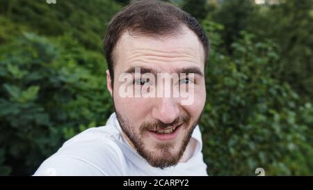 Homme à peau blanche parlant vidéo sur téléphone dans la nature gros plan Banque D'Images