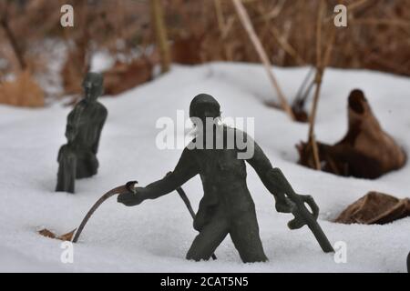 Un soldat en peluche se pend en arrière pour jeter un grenade Neige profonde au genou Banque D'Images