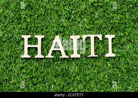Lettre de l'alphabet bois en mot Haïti sur fond vert herbe Banque D'Images