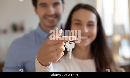 Jeune couple enthousiaste montrant les clés entre les mains de l'appareil photo. Banque D'Images