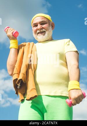 Centre de réadaptation pour les retraités âgés. Homme de sport senior levant des haltères dans le centre sportif. Banque D'Images