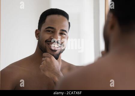 Portrait de tête souriant satisfait Afro-américain homme touchant la barbe Banque D'Images