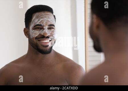 Coup de tête souriant homme afro-américain appréciant la procédure de soin de la peau Banque D'Images