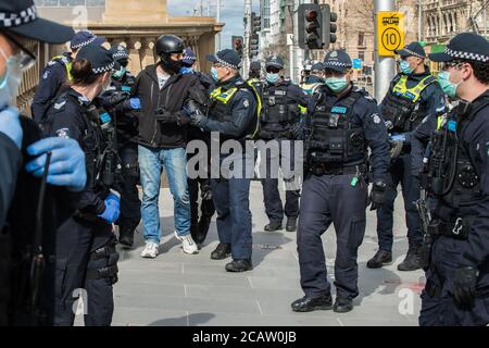 Melbourne, Australie 9 août 2020, les policiers de Victoria arrêtent un homme qui avait refusé de donner ses coordonnées à la police après avoir été arrêté à bord d'un skateboard électrique, à l'extérieur du Parlement de l'État, où une manifestation anti-masque a été prévue. Crédit : Michael Currie/Alay Live News Banque D'Images
