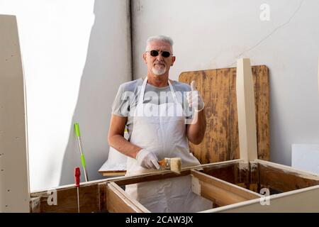 un charpentier professionnel construit une table en bois à l'extérieur atelier Banque D'Images