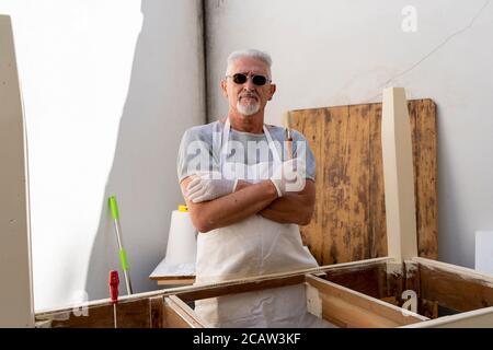 un charpentier professionnel construit une table en bois à l'extérieur atelier Banque D'Images