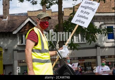 Oxford, Royaume-Uni. 8 août 2020. Les travailleurs et les partisans du NHS ont assisté à un rassemblement sur la place de Bonn à Oxford, appelant à une justice salariale pour tous les travailleurs du NHS, pour protester contre une augmentation de salaire pour refléter leurs efforts durant la pandémie de cavid. Il s'agissait de l'un des quelque 38 rassemblements similaires organisés dans tout le Royaume-Uni. Les manifestants ont maintenu leurs distances sociales et ont porté des masques. Tout en écoutant les orateurs, beaucoup ont tenu des pancartes qui ont mis en évidence leurs griefs et comment ils se sont sentis sous-évalués. Sur la photo, un conférencier tenant le London Weighting pour payer les prix de Londres. Crédit : Stephen Bell/Alay Banque D'Images