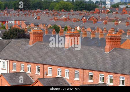 Cheminées en briques au-dessus de maisons mitoyennes à Ashton sous Lyne à Manchester. Banque D'Images