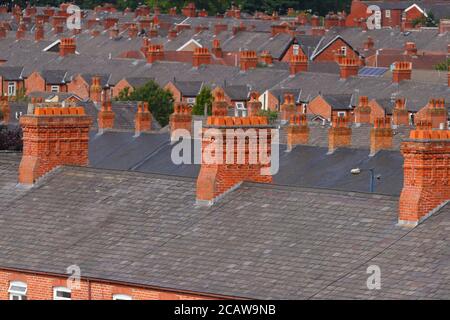 Cheminées en briques au-dessus de maisons mitoyennes à Ashton sous Lyne à Manchester. Banque D'Images