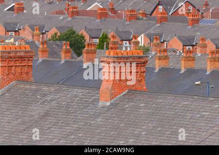 Cheminées en briques au-dessus de maisons mitoyennes à Ashton sous Lyne à Manchester. Banque D'Images