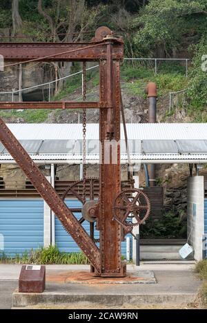 Une nouvelle douche et toilettes à énergie solaire contrastent avec une vieille grue près de la zone de camping de l'île Cockatoo, dans le port de Sydney, en Australie Banque D'Images