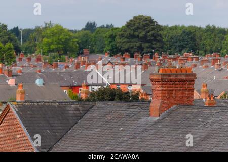 Cheminées en briques au-dessus de maisons mitoyennes à Ashton sous Lyne à Manchester. Banque D'Images