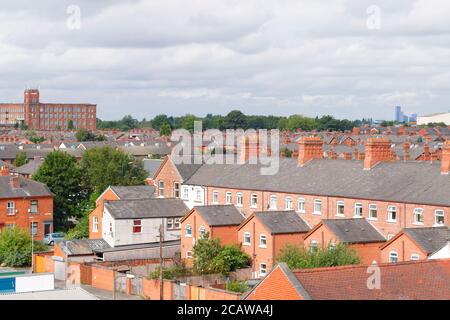 Cheminées en briques au-dessus de maisons mitoyennes à Ashton sous Lyne à Manchester. Banque D'Images