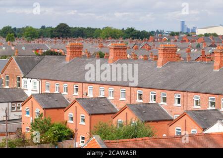 Cheminées en briques au-dessus de maisons mitoyennes à Ashton sous Lyne à Manchester. Banque D'Images