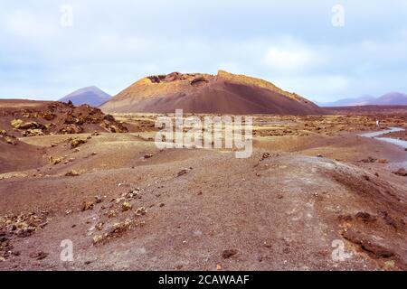 Paysage volcanique aride avec le volcan El Cuervo (le Corbeau) dans le parc naturel des Volcans de Los à Lanzarote, îles Canaries, Espagne. Banque D'Images