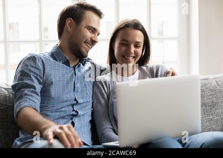 Couple plein de joie émotionnelle regardant un film humoriste sur un ordinateur portable. Banque D'Images