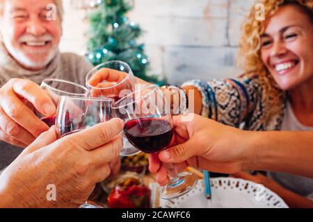 Joyeux famille et amis en dégustant du vin rouge - noël arbre vert de noël en arrière-plan - fête et événement concept traditionnel pour cauc Banque D'Images