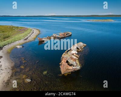 Vue aérienne des vieux navires rouillés abandonnés et abandonnés près de l'île solitaire dans l'océan Arctique. Russie. Mer blanche Banque D'Images