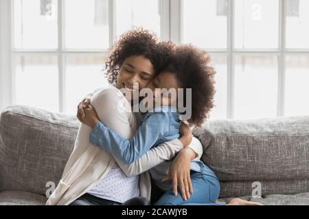 Une maman et une fille afro-américaines affectueuses qui s'embrasse en cuddling Banque D'Images