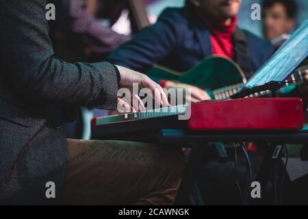 Vue en concert d'un piano à clavier musical pendant un orchestre de jazz musical, mains claviéristes pendant le concert, pianiste masculin sur scène Banque D'Images