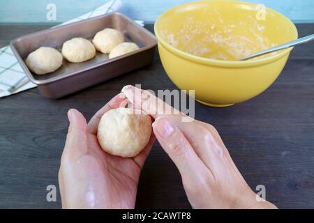 Les mains de l'homme pétrissent la pâte pour cuire du pain au fromage brésilien ou PAO de Queijo Banque D'Images