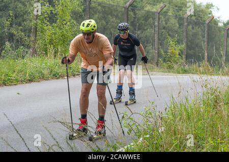 Deux hommes ski à roulettes sur une route tranquille, Aldershot, Royaume-Uni Banque D'Images