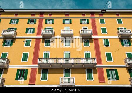 Milan, Italie 08.08.2020: Bâtiment jaune de style italien traditionnel avec balcons dans les rues de Milan Banque D'Images