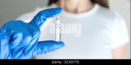 Femme en bleu gant de chirurgie tenant ampoule Banque D'Images