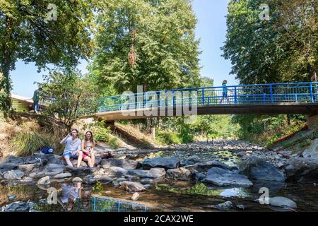 Bad Krozingen, Allemagne. 09e août 2020. Wiktoria et Gabriel (l) sont assis dans le lit de rivière presque sec de la rivière Neumagen, qui coule à travers les jardins thermales de la municipalité de Bad Krozingen. La sécheresse persistante provoque de faibles niveaux d'eau dans les lacs et les rivières du Bade-Wurtemberg. Credit: Philipp von Ditfurth/dpa/Alay Live News Banque D'Images