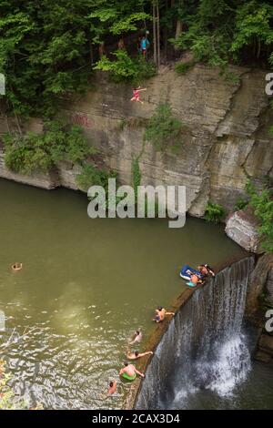 Ithaca, NY/USA-2 août 2020 : une jeune femme saute d'une falaise dans un bassin d'eau naturel à six-Mile Creek. Beaucoup affluent au niveau local, régional et fédéral Banque D'Images