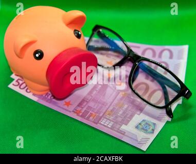 Porcheries de porc et lunettes sur cinq cents des factures en euros sur fond vert Banque D'Images