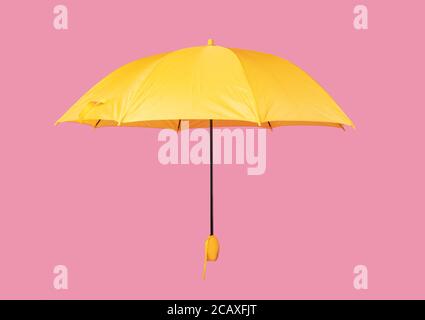 Parapluie jaune ouvert isolé sur fond rose Banque D'Images