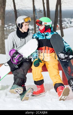 deux snowboarders adorables et amours se reposant sur le sommet de la piste de ski. gros plan. amour, amitié, relation, sentiment, émotion concept Banque D'Images