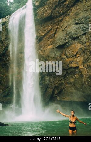 Femme avec une chute d'eau dans le dos ayant le plaisir.