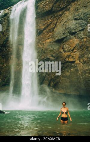 Femme avec une chute d'eau dans le dos ayant le plaisir.