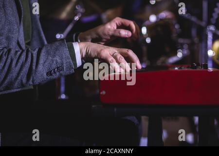 Vue en concert d'un piano à clavier musical pendant un orchestre de jazz musical, mains claviéristes pendant le concert, pianiste masculin sur scène Banque D'Images