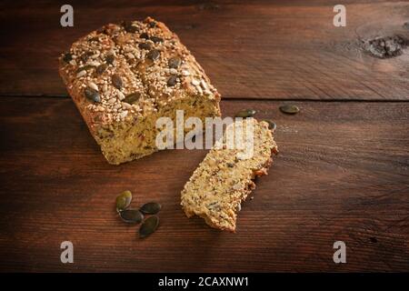 Pain aux protéines sain de farine de lupin, son d'avoine, amande, graines de citrouille et autres ingrédients sains sur une table en bois rustique foncé pour le carb ou le k bas Banque D'Images