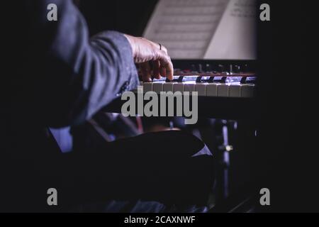 Vue en concert d'un piano à clavier musical pendant un orchestre de jazz musical, mains claviéristes pendant le concert, pianiste masculin sur scène Banque D'Images