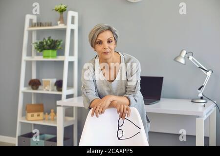Portrait d'une femme âgée aux cheveux gris regardant l'appareil photo souriant dans la pièce. Banque D'Images