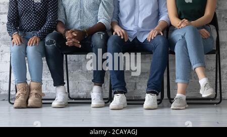 Gros plan sur divers candidats assis en rangée, en attente d'une entrevue d'emploi