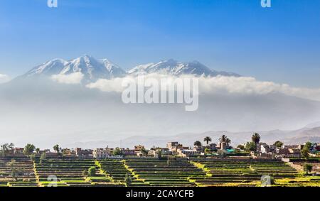 Capes de neige du volcan chachani sur les champs et les maisons de la ville péruvienne d'Arequipa, Pérou Banque D'Images