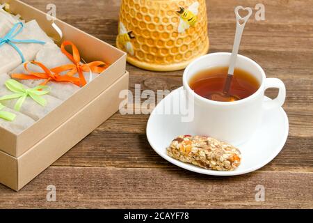 Bar de muesli, une tasse de thé et des boîtes avec des bars. Petit déjeuner sain Banque D'Images